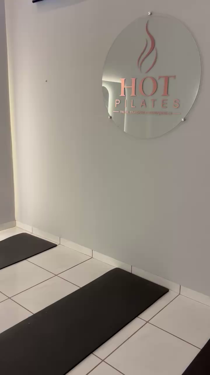 Logo Hot Pilates na parede da sala aquecida do estúdio